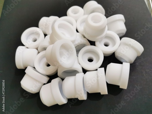 Teflon white, Industrial machinery spare parts, Black background. engineering materials, PTFE (Polytetrafluoroethylene) technical plastics.CNC, milling.