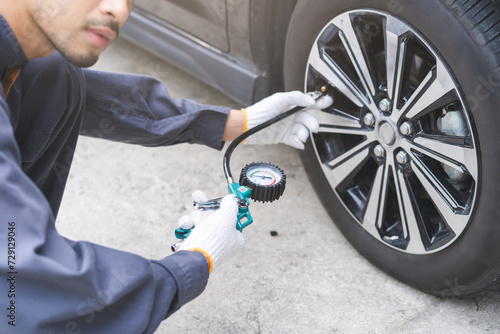 Auto mechanic man checking tire measure air pressure, measurement with gauge for car tyre, mechanic maintenance repair, fix car flat tire with psi pump for safety at vehicle garage, service station
