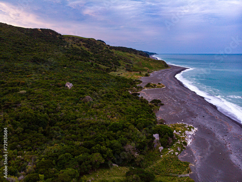 aerial panorama of beautiful nape nape beach in north canterbury, new zealand; black sand beach with turquoise water and large cliffs  photo