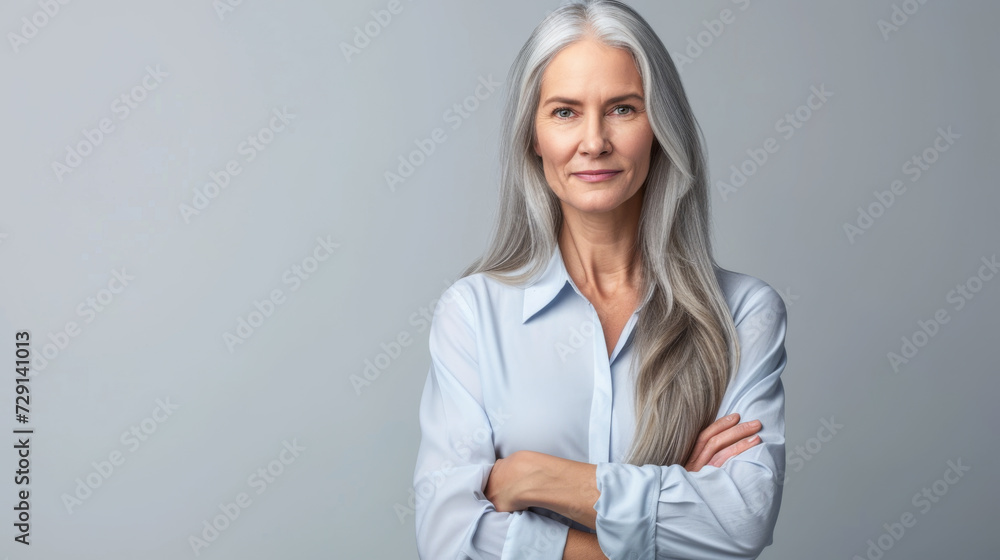 a person with long hair, wearing a light blouse, standing with arms crossed, looking at the camera with a composed and confident demeanor a person with long hair, wearing a light blouse, standing with arms crossed, looking at the camera with a composed and confident demeanor