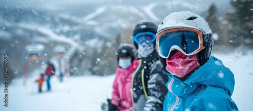 A family at a ski resort on a snowy mountain wearing masks due to COVID-19.