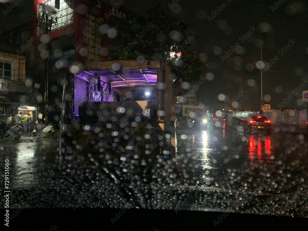 Rain drops on window windshield jaw drop in city at night travel
