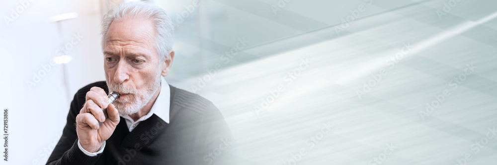 Senior man smoking electronic cigarette; panoramic banner Senior man smoking electronic cigarette; panoramic banner