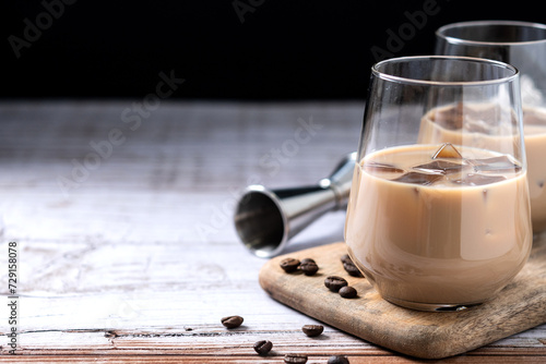 Traditional Irish cream coffee liqueur with ice on wooden table. Copy space photo