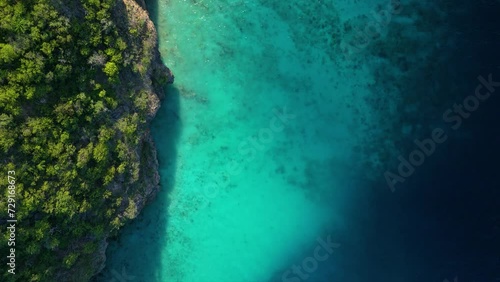 Top down aerial above sandy coral reef dropoff from mysterious tropical cliffs photo