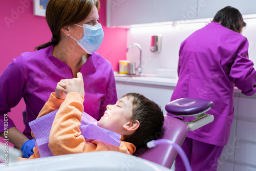 Happy child in the dentist's chair and a female dentist attending to him