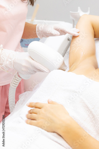 Armpits laser treatment. Close up shot of a young woman having armpits hair removed with a laser hair removal machine by a professional beauty therapist at the beauty spa salon depilation epilation