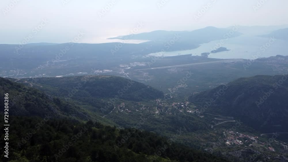 Drone shot of mountain landscape with seaside on a misty day in Kotor Bay in Montenegro Drone shot of mountain landscape with seaside on a misty day in Kotor Bay in Montenegro