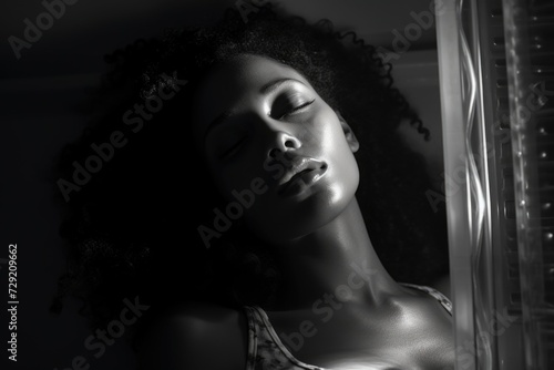 A black and white photo capturing the serene moment of a woman with her eyes closed. This image can be used to convey relaxation, meditation, or inner peace