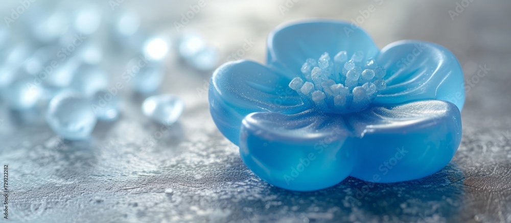 Blue flower-shaped soap placed against a nearby background. Blue flower-shaped soap placed against a nearby background.