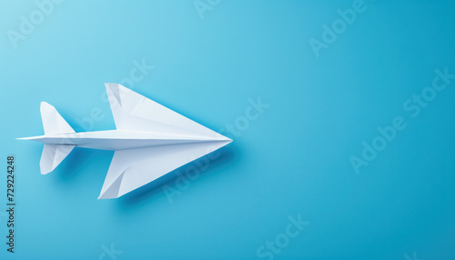 White Paper Airplane on Blue Background photo