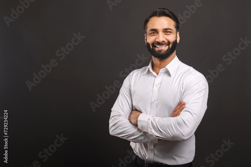 Entrepreneur stands with arms confidently folded, smiling, in a pose that conveys leadership and reliability in corporate setting, portray sense of security and trust that is key for business leaders