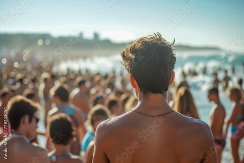 Overpopulation depicted with an image of overcrowded city beach during summer, one young person from the back in focus and overwhelming number of people crowding in the background photo