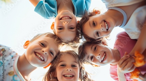 Bunch of cheerful joyful cute little children playing together and having fun. Group portrait of happy kids huddling, looking down at camera and smiling. Low angle, view from below. Fr : Generative AI photo