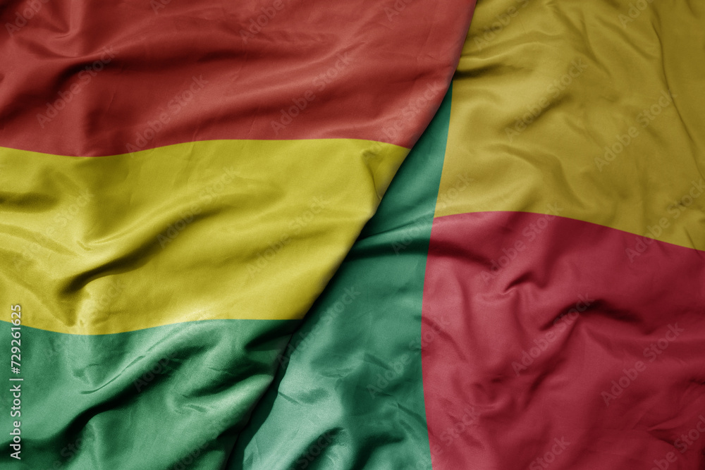 big waving national colorful flag of benin and national flag of bolivia .