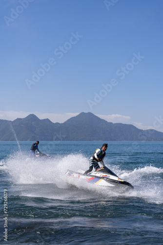 Two Young Hispanic Men Drifting Water with Jet-Skis in Atitlan Lake, Guatemala