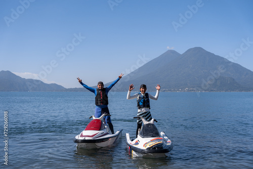 Young Hispanic Men Posing on Jet-Skis with Arms Up at Atitlan Lake, Guatemala photo