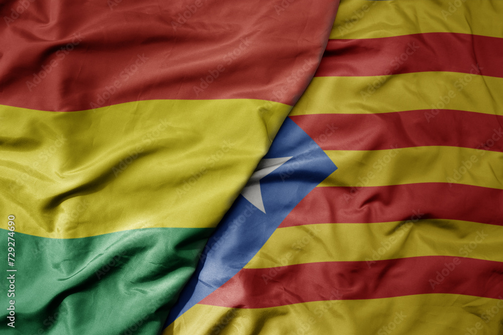 big waving national colorful flag of catalonia and national flag of bolivia .