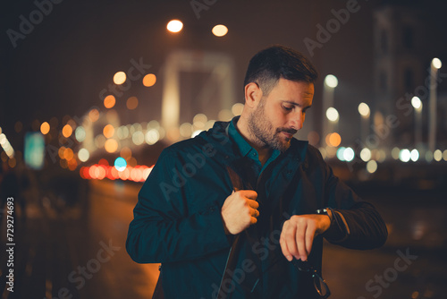 Murais de parede A tired mid adult male employee checking the time on his wristwatch and walking