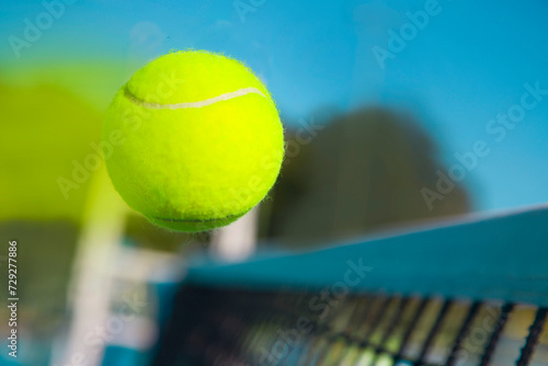 close-up of a tennis ball flying over the tennis net at high speed