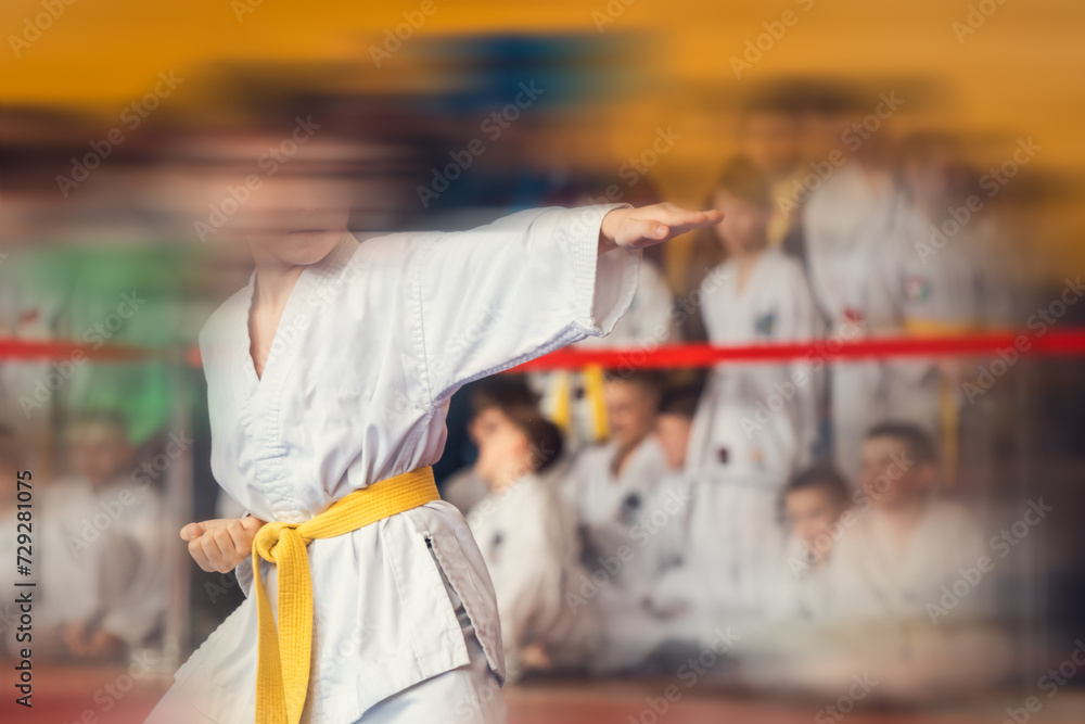 Young man with yellow belt in the gym with motion blur effect and space for text.