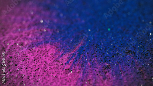 Ink drop. Paint splatter. Defocused blue pink color wet stain blotch spreading motion on grain bokeh light texture abstract background reveal effect.