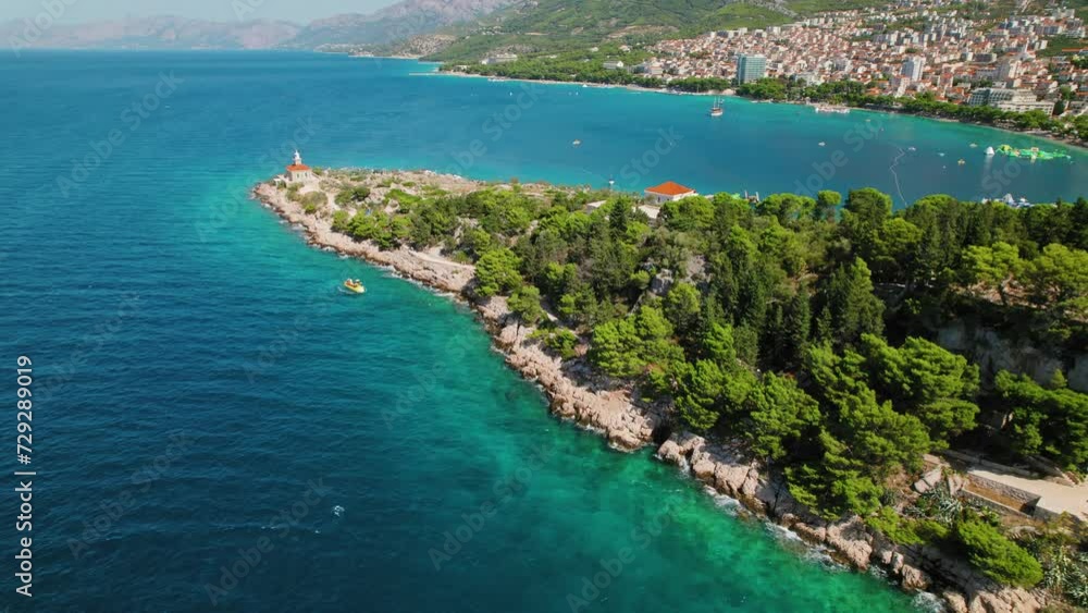 Aerial Vista of Makarska Riviera's Cliffside Lighthouse and Turquoise Sea Waters. Popular tourist destination under the Biokovo mountain. Aerial Vista of Makarska Riviera's Cliffside Lighthouse and Turquoise Sea Waters. Popular tourist destination under the Biokovo mountain.