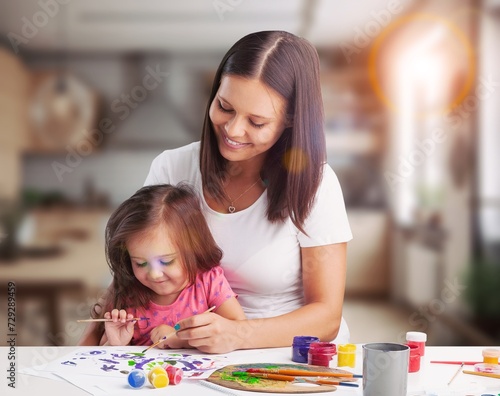 Child doing homework with her mom at home.