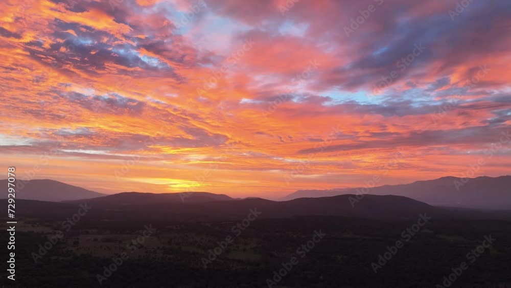 flight at sunset in a valley visualizing in a slight turn to the right the mountains and forests and a spectacular sky with an incredible range of colors blue, red yellow orange in Avila-Spain flight at sunset in a valley visualizing in a slight turn to the right the mountains and forests and a spectacular sky with an incredible range of colors blue, red yellow orange in Avila-Spain