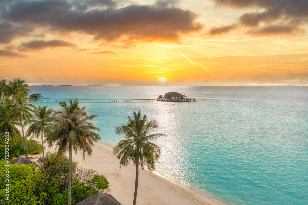 Picturesque aerial landscape luxury tropical island resort water villas. Beautiful island beach palm trees, sunset sea sky. Amazing bird eyes view Maldives paradise tourism coast. Exotic best vacation