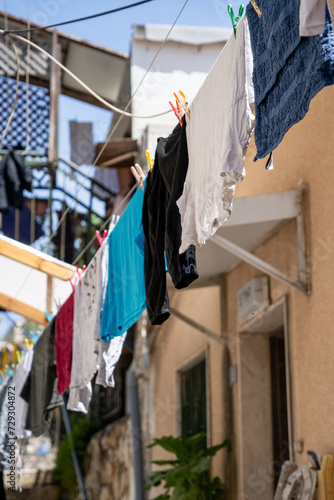 Multi-colored laundry is dried on lines with clothespins in the courtyard of the house (166)