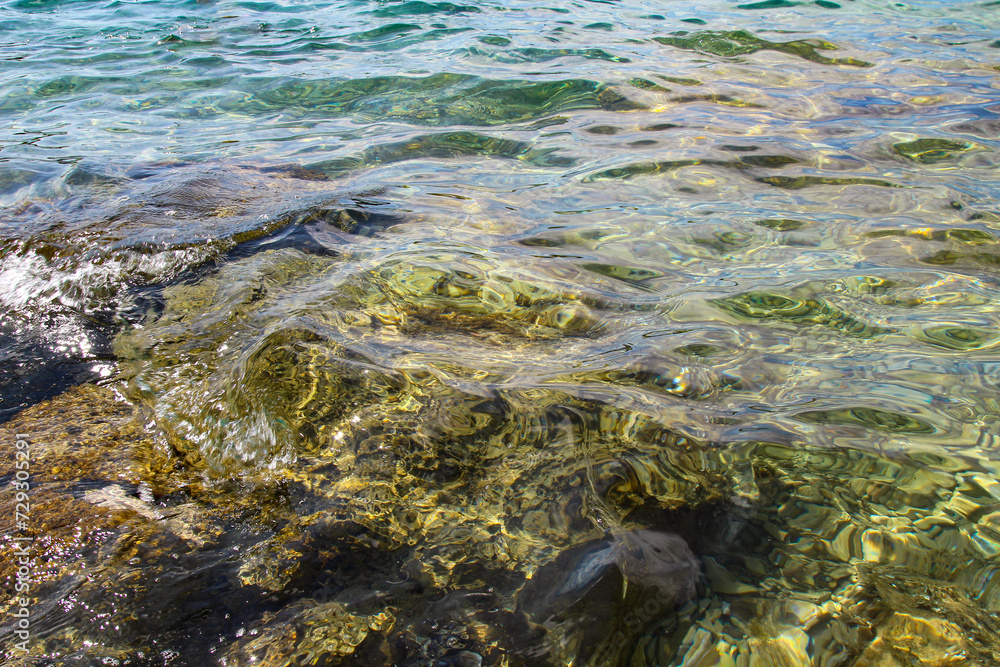 Blue Mediterranean Sea. Clear Water. Stones at the Bottom of the Mediterranean Sea. Small Waves. Blue Mediterranean Sea. Clear Water. Stones at the Bottom of the Mediterranean Sea. Small Waves.