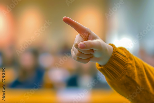 A hand pointing towards audience members, business man points his finger inviting questions or interactions during a presentation.