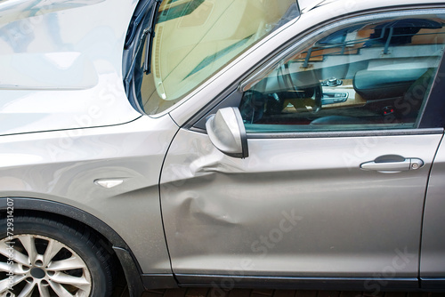 car door with large dent damage after road collision, view from above. Car body side damage, traffic accident. Dents on the car door. Bodywork concept.