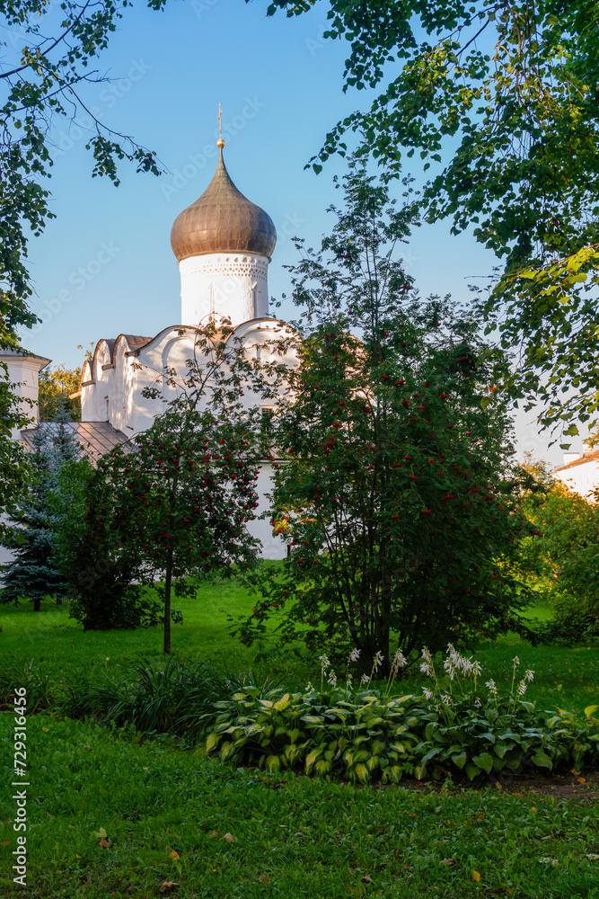 Fototapeta premium Pskov, Russia, September 6, 2023. Garden in front of an ancient Orthodox church.