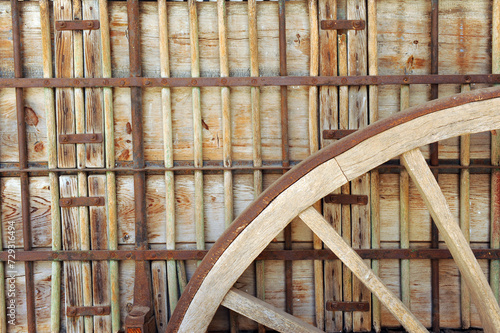 Primer plano de la rueda de un viejo carro agrícola de madera y refuerzos de hierro usado en la Mancha en las labores del campo y la agricultura para carga y transporte de paja y cereales photo