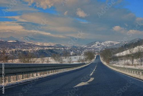 Winter scene of a road and mountains in rural area