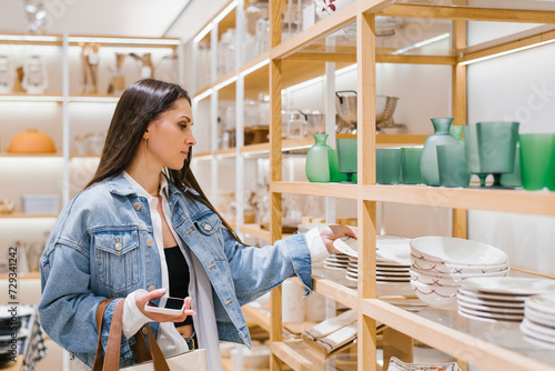 Young woman chooses crockery in a home improvement shop