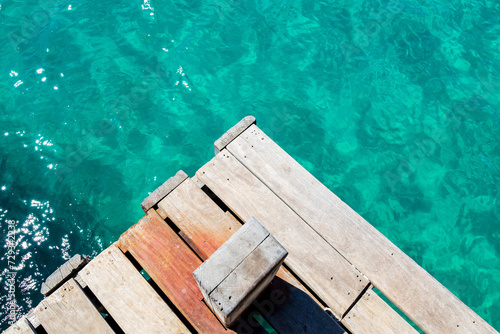 Abstract image of the contrast between the turquoise water and the wooden pier at Praia do Aventureiro, a tropical paradise in Ilha Grande, Angra dos Reis, Rio de Janeiro, Brazil.