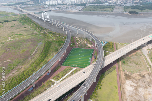 A soccer stadium located at the intersection of a road and a road where cars travel. 