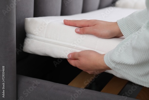 Woman putting new soft mattress on bed, closeup © New Africa