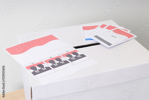 The voting paper of general elections or Pemilu for the president and government of Indonesia on the ballot box. Isolated image on white background photo