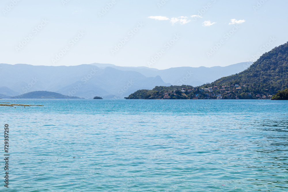 Fototapeta premium Landscape of Dentista beach during a beautiful sunny morning. One of the most beautiful beaches in Brazil and Rio de Janeiro, located on a small island with white sand and crystal clear water.