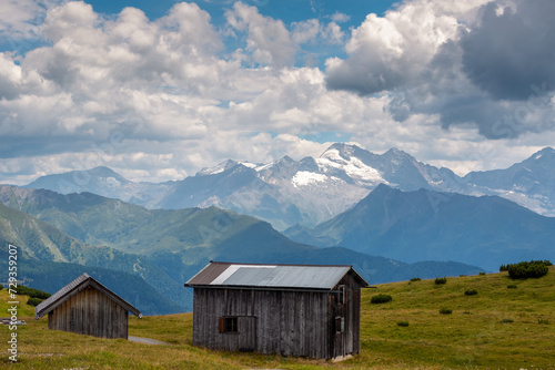 Old wooden cabins in the Stubai Alps and a scenic panoramic view of Zillertal Alps with Olperer peak 3476 m. photo