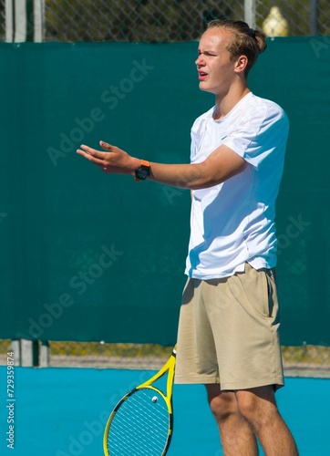 Tennis player playing tennis on a hard court on a bright sunny day 