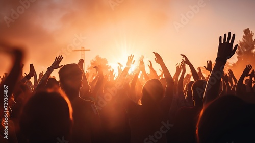 Silhouettes of unrecognizable people holding hands up and having fun during amazing music performance
