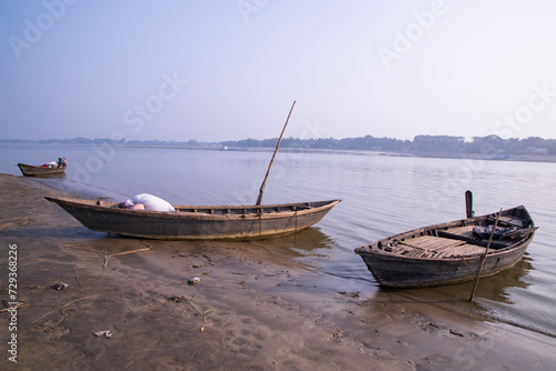 landscape view of Some wooden fishing boats on the shore of the Padma river in Bangladesh © Artyponds
