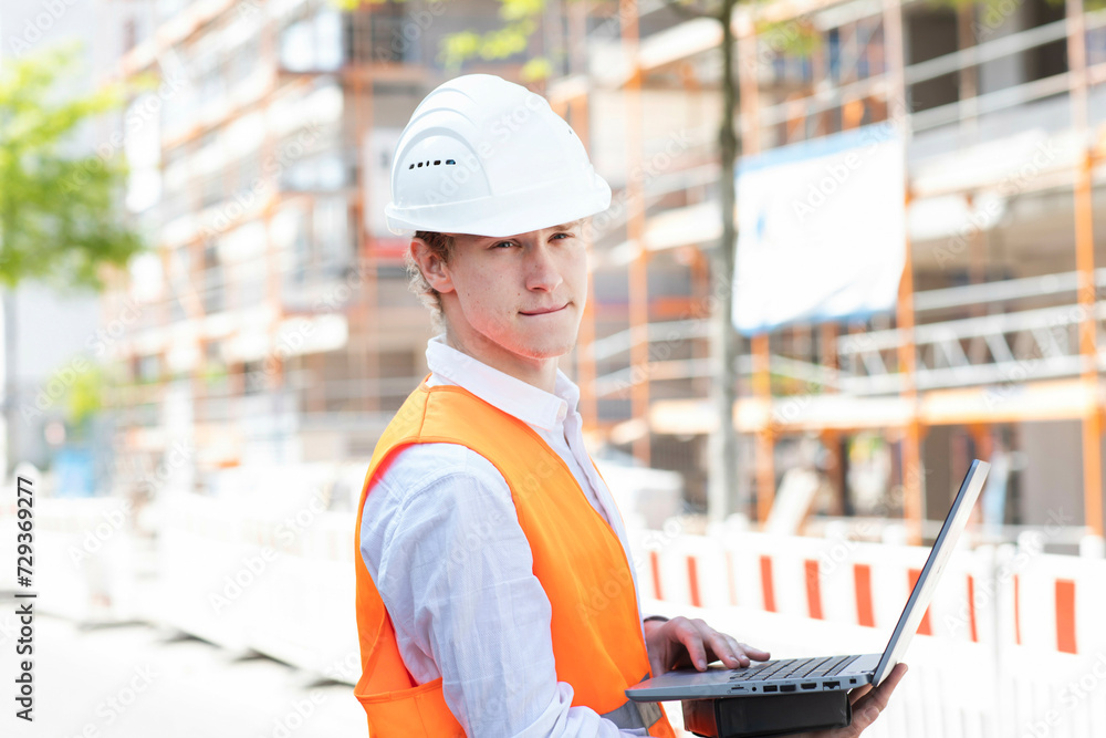 Engineer with helmet working outside new building Engineer with helmet working outside new building