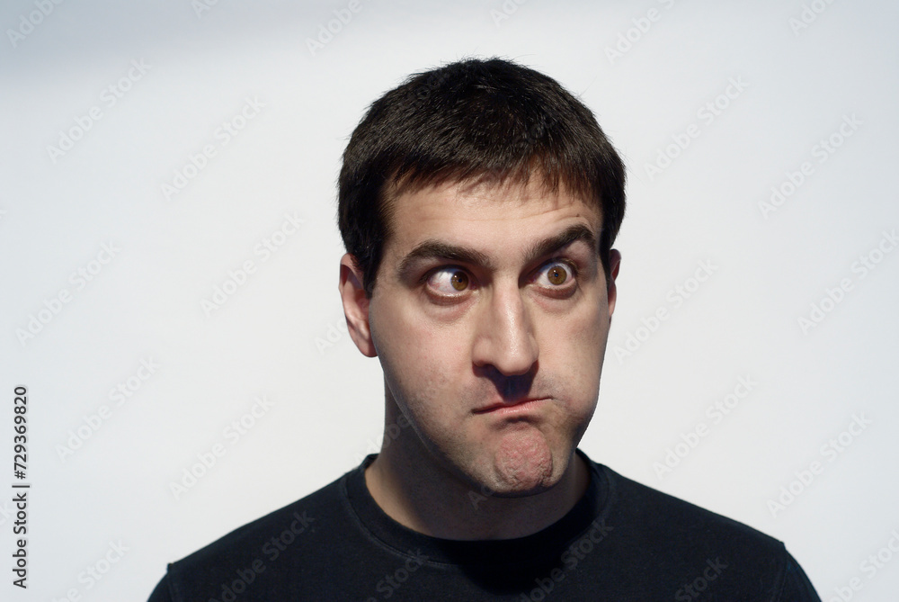 Adult man grimacing with his face and gesturing with his hands Adult man grimacing with his face and gesturing with his hands