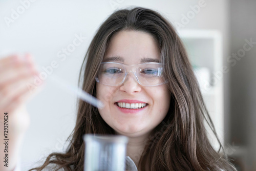scientist young woman working in a labor with lab glasses photo